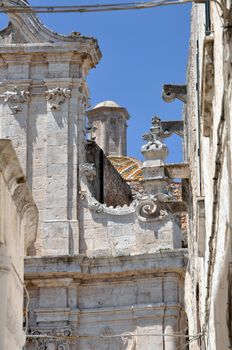 Ostuni lane in the Old Town (the White City) with a dome in the background, Puglia, Italy