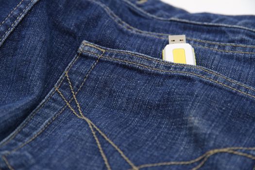 Yellow USB drive in the pocket of jeans