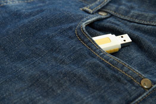 Yellow USB drive in the pocket of jeans