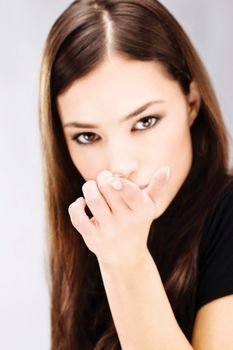 Young woman holding contact lens on finger in front of her face