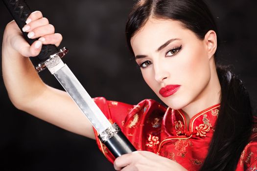 Pretty woman holding katana weapon