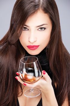 Portrait of a pretty woman with pelt, holding glass of brandy