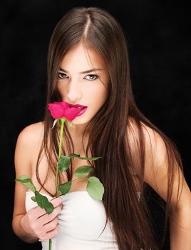 Portrait of a woman with wet red rose on black background