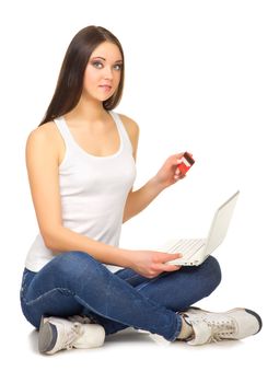 Young girl with laptop and credit card isolated