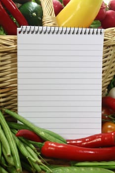 Ruled note pad and a variety of vegetables