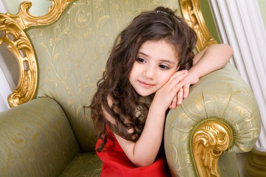 small girl with long hair in the armchair