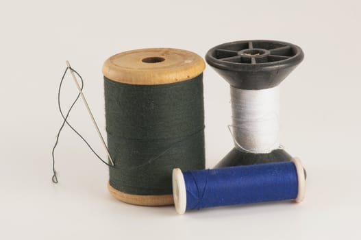 Spool of thread with needle  on white background