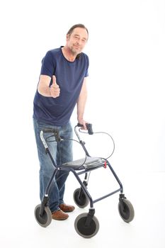 Happy male patient using a medical walker giving a thumbs up gesture to show his confidence in his recovery and hope for the future Happy male patient using a medical walker giving a thumbs up gesture to show his confidence in his recovery and hope for thw future 