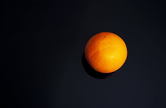 The whole ripe fruit of orange on glass