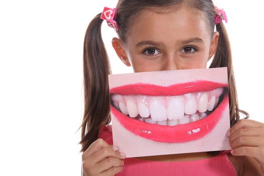 Little girl holding photo of mouth