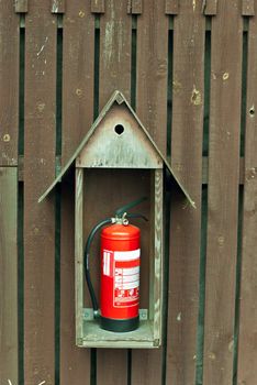 a fire extinguisher on the wall of a wooden shed
