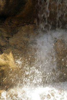 The flow of water falls with solar flares falling from a rock