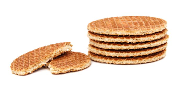 Stroopwafels, Dutch caramel waffles piled up, with one broken in half, isolated on a white background