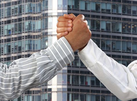 Arm wrestling in the office  over business corporate building