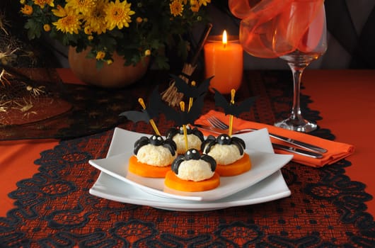 Cheese balls with olives spiders and bats on a festive table