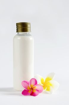 white  bottle and  fresh frangipani  on white background