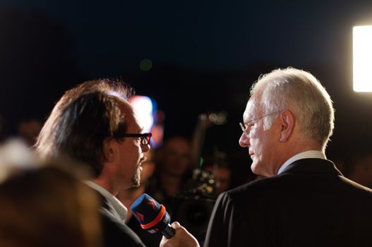 STUTTGART, GERMANY - JULY 25: Harald Schmidt, the most famous German talkmaster, is interviewing comedian Christoph Sonntag as a guest at the public viewing of the premiere of Mozart´s opera “Don Giovanni” in front of the Opera building in Stuttgart, Germany on July 25, 2012.