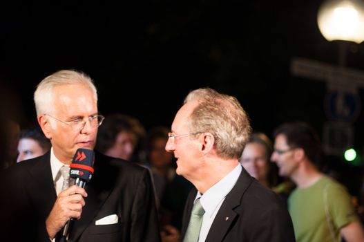 STUTTGART, GERMANY - JULY 25: Harald Schmidt, the most famous German talkmaster, is interviewing Stuttgart Lord Mayor Wolfgang Schuster as a guest at the public viewing of the premiere of Mozart´s opera “Don Giovanni” in front of the Opera building in Stuttgart, Germany on July 25, 2012.