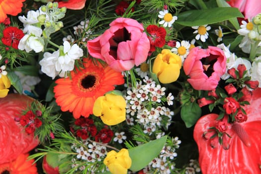 Flower arrangement with different flowers in orange, yellow, pink and red