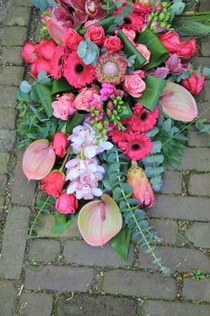 Big sympathy bouquet in different shades of pink on the pavement
