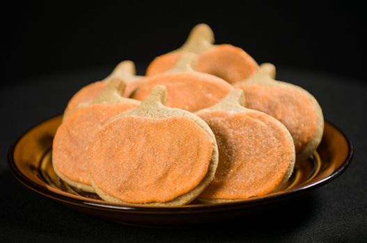 Homemade pumkin cookies on isolated black background.