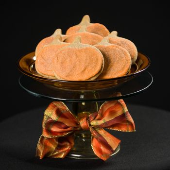 Homemade pumkin cookies on isolated black background.