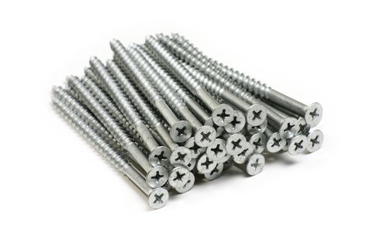 pile of four inch wood screws on isolated white background.