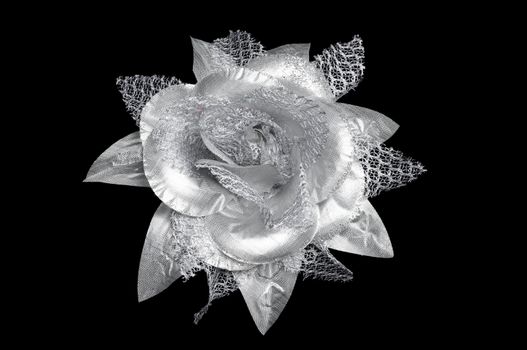 A silver flower hair clip for women on isolated black background with vector path.