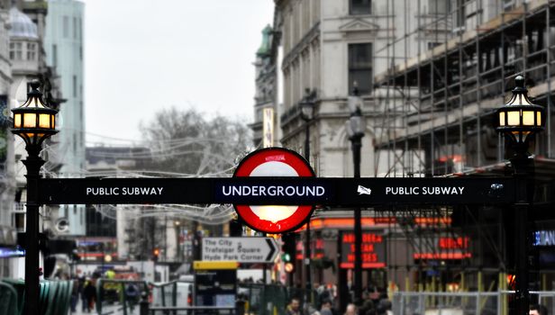 London subway sign, city background.