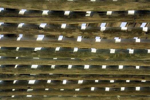 Stylized wooden pergola roof against the blue sky is visible through the roof structure pergolas