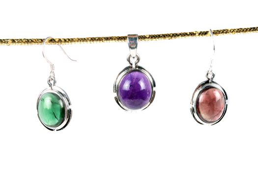 Pendants made with different colors in green, violet and orange, on white studio background.