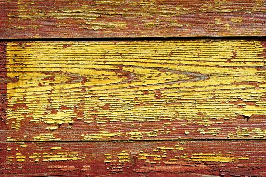 Detail of old wooden shelled boards painted in red and yellow 