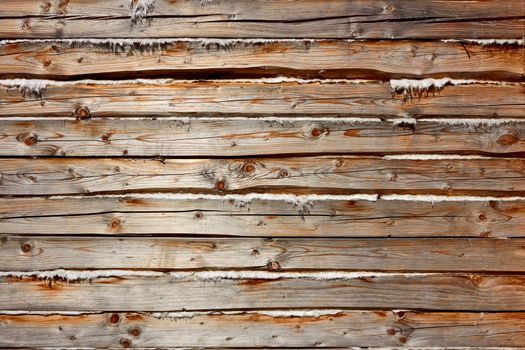 Old wooden logs with heat insulation material between them. Part of wooden house walls