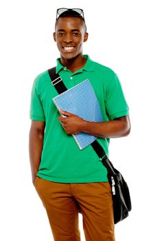 College student with sunglasses over his head, holding spiral notebook