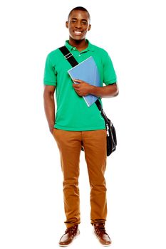 Smiling african student carrying laptop bag and notebook, full length portrait