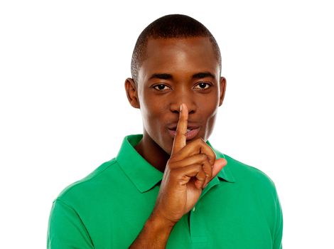 Young african guy showing silence gesture with finger on his lips