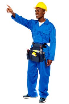 Young african male worker pointing at copy space, full length portrait