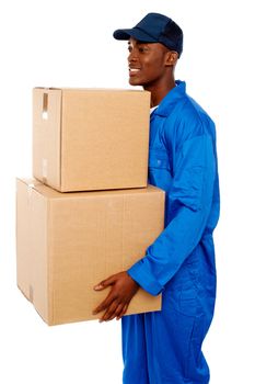 Young courier boy moving boxes looking away. Great services