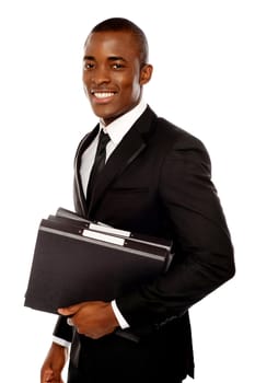 Handsome young executive holding files looking at camera