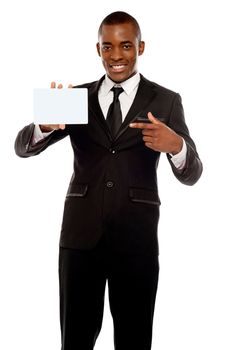 Business promoter pointing at blank placard looking right into camera