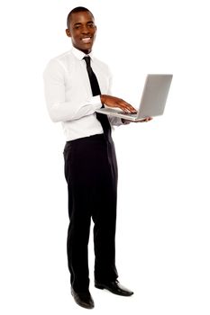 Full length portrait of businessperson holding laptop and using