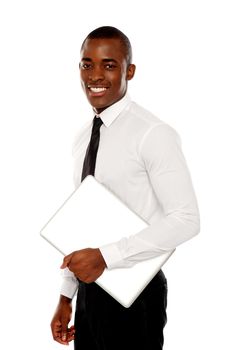 African businessman carrying laptop and looking at camera