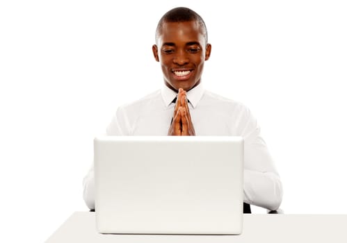 Cheerful african male manager looking at laptop screen, business concept
