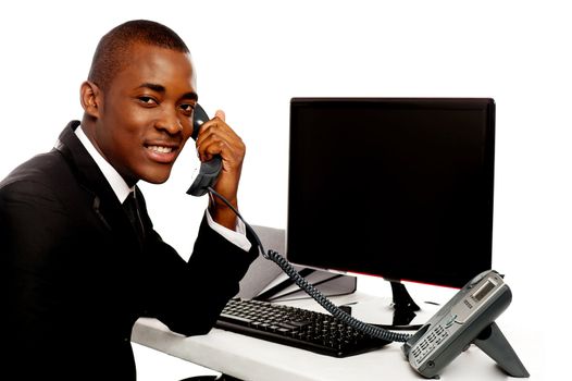 Smiling african businessman communicating on phone looking at camera