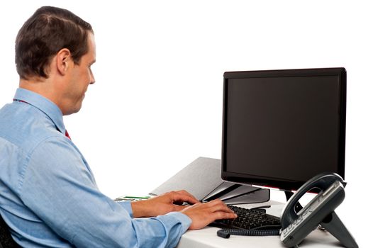 Side view male accountant working in office in front of computer screen