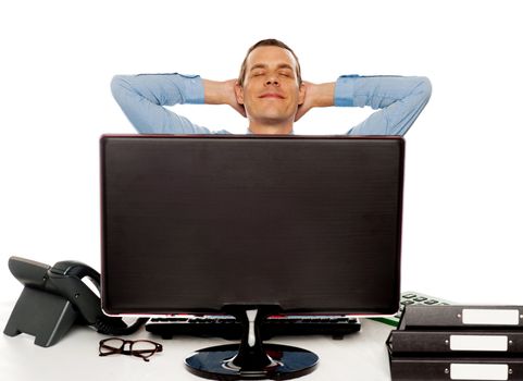 Young businessman posing in a relaxed manner with hands behind head