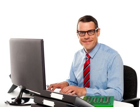 Happy young corporate man using computer against white background