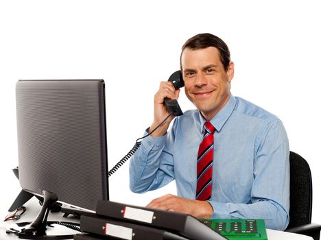 Businessman talking on phone, handling clients while working on computer