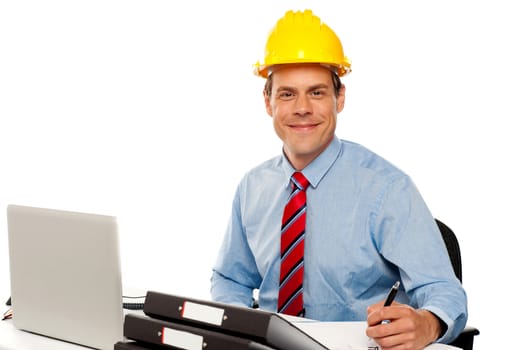 Portrait of handsome architect writing notes and working in office