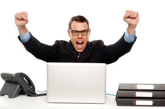 Excited businessman shouting and rejoicing his victory. Wearing glasses and arms raised up